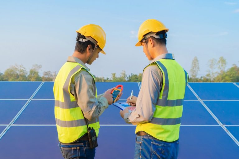 Portrait of engineer man or worker, people, with solar panels or solar cells on the roof in farm. Power plant with green field, renewable energy source in Thailand. Eco technology for electric power